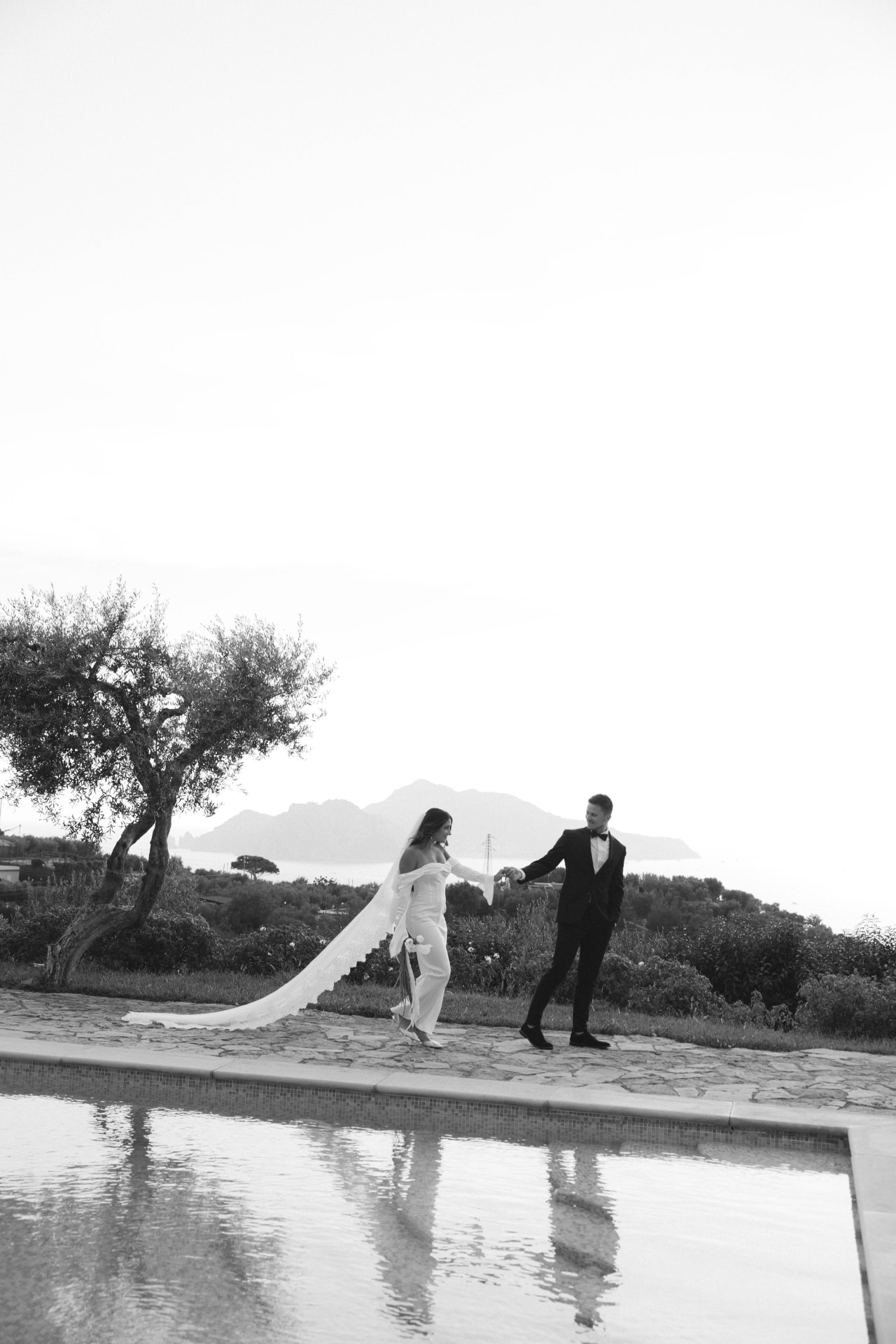 Brendan and Alexa walking hand in hand by the water in Sorrento, Italy