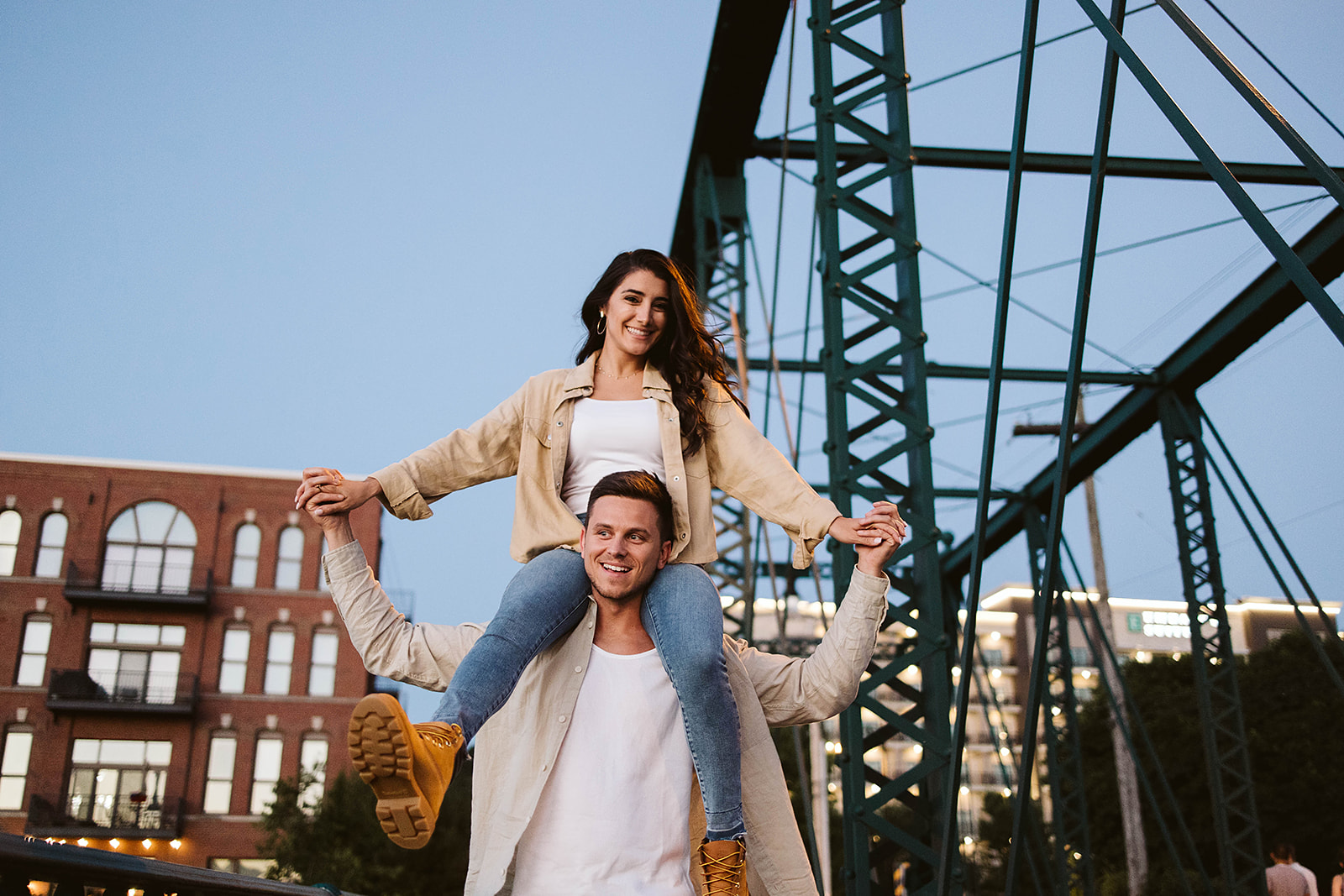 Brendan and Alexa laughing together on a city bridge